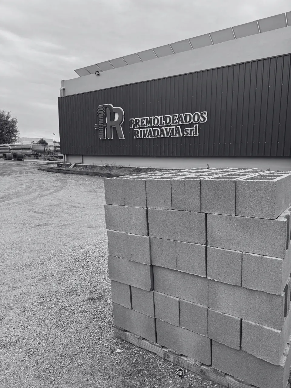 Frente de la planta de Premoldeados Rivadavia SRL con bloques de hormigón apilados